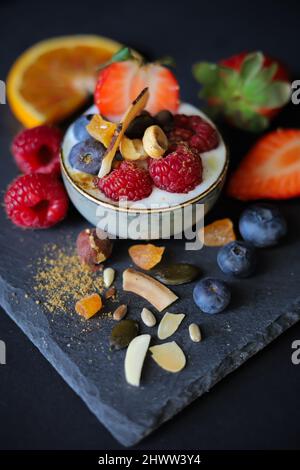 Hausgemachtes Müsli mit Mandel, trockener Aprikose, Kokosnüssen, Sonnenblumen, Kürbis und Flexkernen, serviert mit natürlichem Joghurt, frischen Früchten und Garam Masala Stockfoto