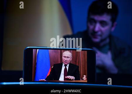Wladimir Putin Rede im Fernsehen. Wolodymyr Zelenski der Präsident der Ukraine im Hintergrund . Wolodymyr Zelenskyy Rede vor den Menschen im Fernsehen Stockfoto