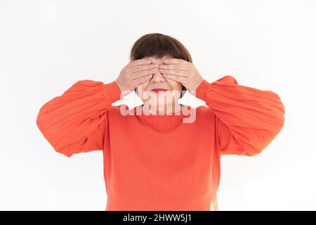 Alte Brünette Frau macht die sehen keine Geste von den drei weisen Affen - Studiofoto Stockfoto