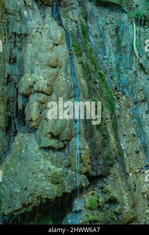 Foto zeigt felsige Schlucht, in der ein Gebirgsfluss fließt. Der Fluss fließt durch riesige Steinblöcke. Die bezaubernde Tierwelt der karibischen Insel begeistert mit Witz Stockfoto