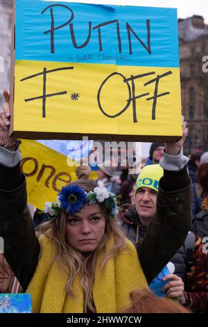 Protest gegen die russische Invasion der Ukraine, Trafalgar Square, London, England. Ukrainerin mit blauem und gelbem Flaggenschild, auf dem Putin F steht. Stockfoto