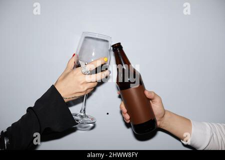 Minimale Nahaufnahme eines jungen Paares, das bei einer Party Drinks anklirrst, mit Blitz aufgenommen Stockfoto