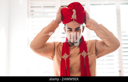 Turban Up, seine Hochzeitszeit. Aufnahme eines hübschen jungen Mannes, der sich an seinem Hochzeitstag anzieht. Stockfoto