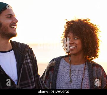 Oh, du denkst, du bist lustig Aufnahme eines jungen Paares, das einen Spaziergang am Strand genießt. Stockfoto