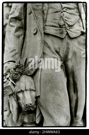 Detail eines Hundes an der Seite seines Meisters in einer Statue auf dem Friedhof Pere Lachaise in Paris, Frankreich Stockfoto