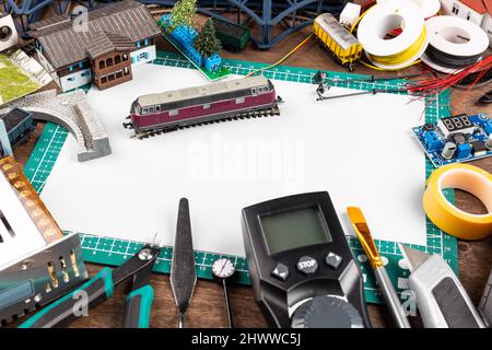 Bau einer Modelleisenbahnanlage. werkbank mit Modelleisenbahnstation Brückengleise kopieren Raum- und Landschaftswerkzeuge. Hobby-Freizeitmaßstab Stockfoto