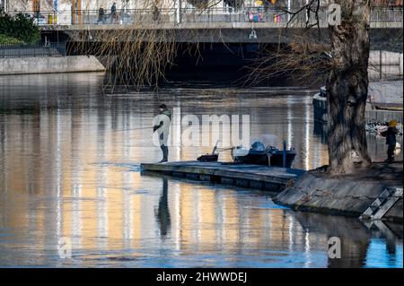 Mann, der im Frühjahr am Motala River in Norrkoping angeln konnte. Norrkoping ist eine historische Industriestadt in Schweden. Stockfoto