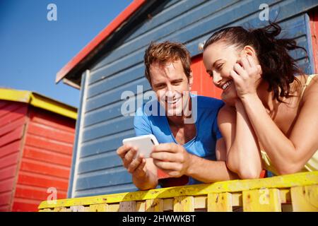 Sehen Sie sich dieses Bild an. Zugeschnittene Aufnahme eines Paares, das im Urlaub Fotos ansah. Stockfoto