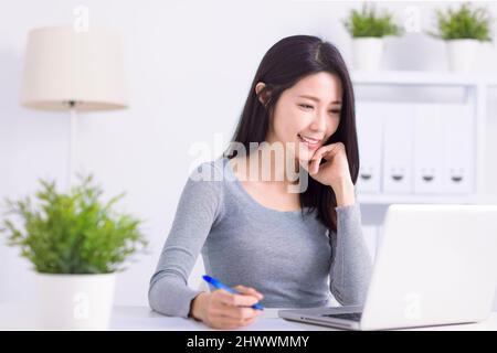 Junge Geschäftsfrau, die einen Laptop benutzt und im Home Office arbeitet Stockfoto