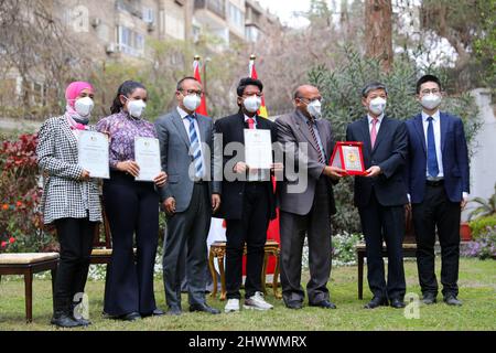 Kairo, Ägypten. 3. März 2022. Der chinesische Botschafter in Ägypten Liao Liqiang (2. R) posiert für ein Gruppenfoto mit drei ägyptischen Kindern, Joumana Mohamed Mostafa (1. L), Rana Ahmed Abdelwahab (2. L) und Sajed Mohamed (4. L), die am 3. März 2022 in Kairo, Ägypten, den Young Cultural Ambassador to China Award gewonnen haben. Die drei Kinder erhielten den Preis für ihre herausragenden Arbeiten über die Olympischen Winterspiele in Peking in einem internationalen Wettbewerb in China. Quelle: Sui Xiankai/Xinhua/Alamy Live News Stockfoto