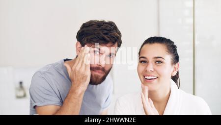 Das Erscheinungsbild aufrecht erhalten. Aufnahme eines glücklichen jungen Paares, das zu Hause im Badezimmer ihre morgendliche Pflegeroutine gemeinsam durchläuft. Stockfoto