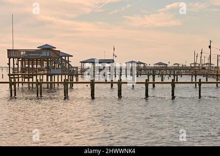 Hölzerne Docks, Piers, Bootshäuser und Pfeiler entlang der Küste der Mobile Bay an der Golfküste, in der Nähe von CODEN Alabama, USA. Stockfoto