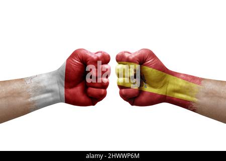 Zwei Hände schlagen sich gegenseitig auf weißem Hintergrund zu. Länderflaggen bemalten Fäuste, Konfliktkrisenkonzept zwischen malta und spanien Stockfoto