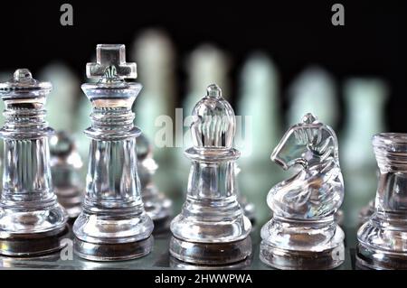 Klare und mattierte Schachfiguren auf dem passenden Schachbrett Stockfoto