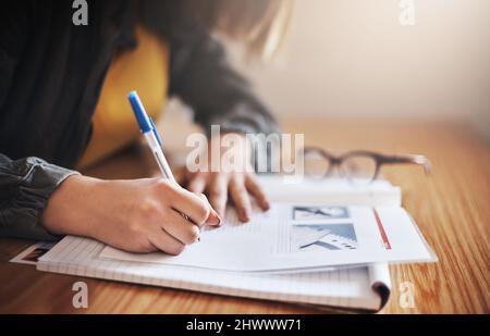 Ihre Studienmethoden sind Notizen. Ausgeschnittene Aufnahme einer nicht erkennbaren Studentin in der Klasse. Stockfoto