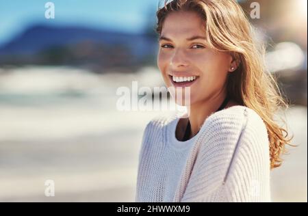 Meer am Tag. Aufnahme einer jungen Frau, die am Strand steht. Stockfoto