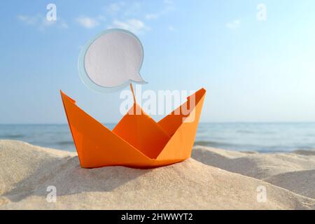 Orange Papier Boot auf Sandy Seashore Nahaufnahme kleines Boot aus Papier auf dem Hintergrund Stockfoto