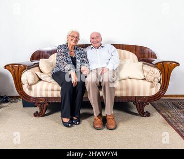 Kaukasische senior Paar in Liebe sitzen auf einem Sofa Stockfoto