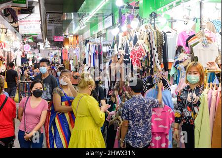 Thai Menschen tragen chirurgische Maske Einkauf billige Kleidung auf Großhandelsmarkt auf Pratunam Stockfoto