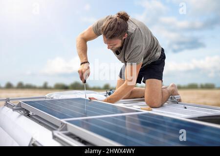 Person, die an Solarzellen auf einem Transporter arbeitet Stockfoto