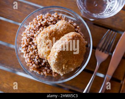 Gekochter Buchweizen mit Fleischschnitzel auf dem Tisch Stockfoto