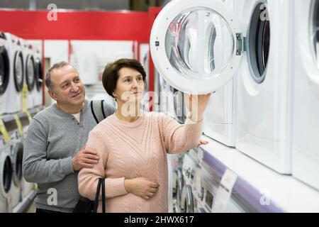 Europäische Ehegatten im reifen Alter entscheiden sich für eine Waschmaschine Stockfoto