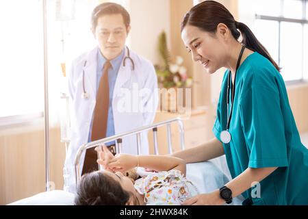 Kinderarzt besucht Eltern und Kind im Krankenhaus Bettstation, Arzt und Krankenschwester treffen und sprechen mit Patienten Kind, Gesundheitswesen medizinischen Service Behandlung Stockfoto