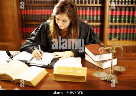 Shes ein Experte in der Rechtswelt. Aufnahme einer jungen juristischen Fachkraft, die in einem Arbeitszimmer an ihrem Schreibtisch sitzt. Stockfoto