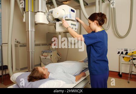 Der Radiologe richtet die Bildgebungssteuerung ein, indem er das Licht auf den gewünschten Bereich des Patienten richtet. (MODELL FREIGEGEBEN) Stockfoto