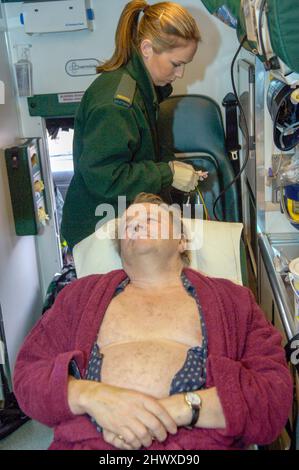 Ein Medizintechniker bereitet sich darauf vor, die Elektroden an der Brust eines älteren Mannes anzubringen. (MODEL RELEASED) Stockfoto