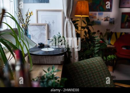 Teil des Wohnzimmers in der Wohnung mit altmodischen Möbeln, Interieur und Nadelspieler mit Vinyl-Schallplatte auf Fensterbank Stockfoto