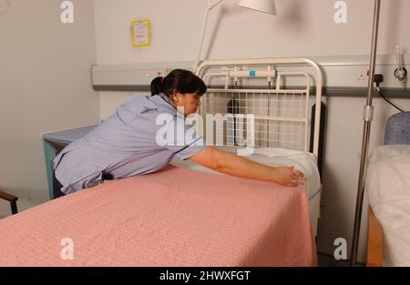 Staff Nurse macht ein Bett auf einer Krankenstation.(MODEL RELEASED) Stockfoto