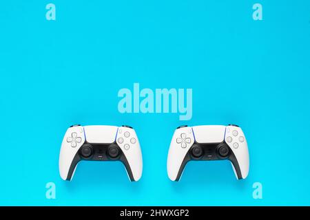 Ternopil, Ukraine - 05. März 2021: Zwei dualsense playstation 5-Controller auf blauem Hintergrund, Spielkonzept. PS 5-Gamepad Stockfoto