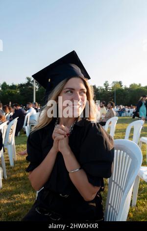 Graduierter Student, der mit Kappe steht. Das Mädchen absolvierte die Universität und sie ist so glücklich und stolz. Bachelor-Abschluss. Bildungsleistung. Stockfoto