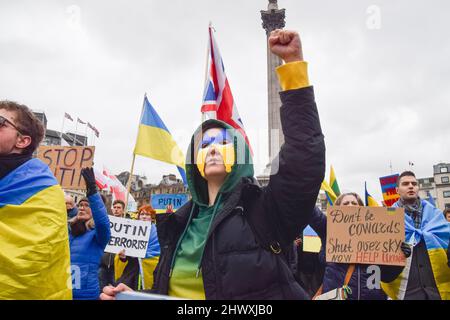 London, Großbritannien. 5.. März 2022. Ein Protestler trägt eine Maske mit den Farben der ukrainischen Flagge. Tausende von Menschen versammelten sich am elften Tag der Proteste auf dem Trafalgar Square, während der russische Angriff auf die Ukraine fortgesetzt wird. Stockfoto