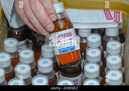 Pharmazeutischer Arbeiter mit einer Flasche Cephalexin Cefalexin wird verwendet, um eine Reihe von bakteriellen Infektionen zu behandeln, einschließlich: Mittelohr-Infektionen, st Stockfoto