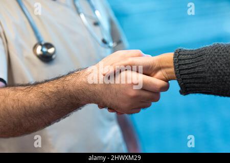 Arzt begrüßt den Klienten im Krankenhaus mit einem Handschlag Stockfoto