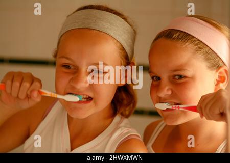 Zwei Mädchen putzen ihre Zähne (MODEL VERÖFFENTLICHT) Stockfoto