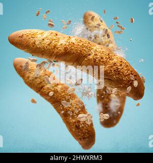 Frisch gebackene Brötchen fliegen in der Luft. Kreatives Frühstückskonzept. Stockfoto