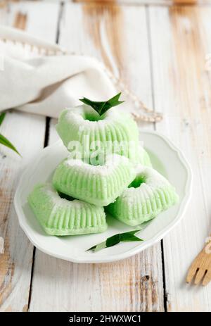 Indonesische traditionelle Dampfkuchen Kue Putu Ayu, hergestellt aus Reismehl, geriebenen Kokosnuss-, Pandanus- und Suji-Blättern für grüne Farbe, serviert in White Plat Stockfoto