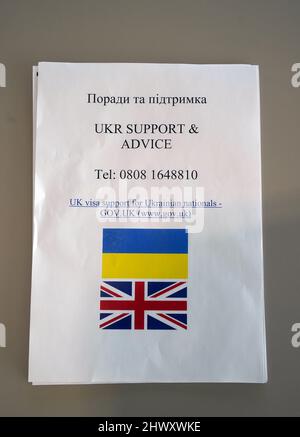 Eine Mitteilung der britischen Regierung an einem Begrüßungsschalter am Fährterminal in Calais, Frankreich, als ukrainische Flüchtlinge an dem Ort eintreffen, um nach Großbritannien zu gelangen. Bilddatum: Dienstag, 8. März 2022. Stockfoto