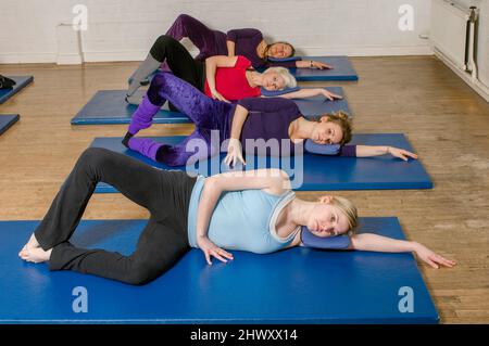 Eine Übungsklasse im Body Control Center in London übt die Pilates Oyster Position. Pilates ist das körperliche Fitness-System in der e entwickelt Stockfoto