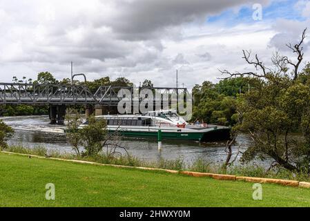 Die Dawn Fraser rivercat Fähre auf dem Parramatta River führt über eine Eisenbahnbrücke Stockfoto