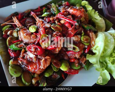 Traditionelle thailändische Gerichte aus dem Süden rühren gebratene Garnelen mit Sataw- oder Stinkbohne mit Sauce-Garnelenpaste für Gäste, die auf dem Tisch im Restaurant serviert werden Stockfoto