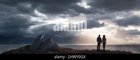 Mann und Frau lieben das Paar, das an der Rocky Ocean Coast steht. Stockfoto