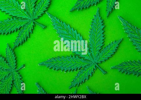 Happy 420, Cannabis Indica Blatt und Marihuana Hintergrund Muster Konzept Thema mit vielen künstlichen Hanf Blätter isoliert auf grünen Hintergründen Stockfoto