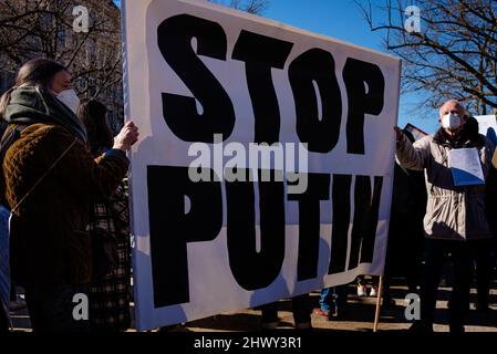 Berlin, Berlin, Deutschland. 8. März 2022. Unter dem Motto „Frauen und Mütter aller Länder – vereinigt euch!“ halten Demonstranten vor der russischen Botschaft in Zentral-Berlin ein großes Transparent mit der Aufschrift „Stoppt Putin“, das sich solidarisch mit Frauen und ihren Familien in der Ukraine und Russland zum Internationalen Frauentag 2022 präsentiert. Und „kein Krieg trennt uns“. Die Organisatoren heben die besondere Situation von Frauen und Kindern in Konflikten hervor, wobei ein besonderer Fokus auf den anhaltenden Krieg in der Ukraine und die aufkommende zivilgesellschaftliche Protestbewegung in Russland liegt. (Bild: © Jan Scheunert/ZUMA Press Wire) Stockfoto