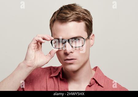 Sieh dir meine neuen Rahmen an. Porträt eines hübschen jungen Mannes mit Brille. Stockfoto