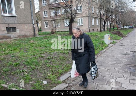 Sofia, Bulgarien.eine ältere Erwachsene kaukasische Frau, die von den Geschäften und Supermärkten mit ihren täglichen Lebensmitteln nach Hause geht. Stockfoto