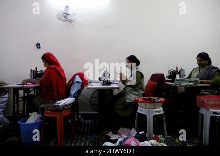 Neu-Delhi, Indien. 07. März 2022. Indische Mitarbeiterinnen stellen am Internationalen Frauentag in einer Einrichtung auf dem Goonj-Campus (Non-Profit Organisation) in Neu Delhi wiederverwendbare Damenbinden aus Baumwolltuch her.die NGO (Non-Governmental Organisation) will Zugang zu billigen Damenbinden und Kampagnen zur Beendigung der Menstruationsregierungen in der konservativen indischen Gesellschaft durchführen. Kredit: SOPA Images Limited/Alamy Live Nachrichten Stockfoto